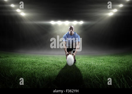 Zusammengesetztes Bild des Porträts von Rugby-Spieler mit Ball kniend Stockfoto