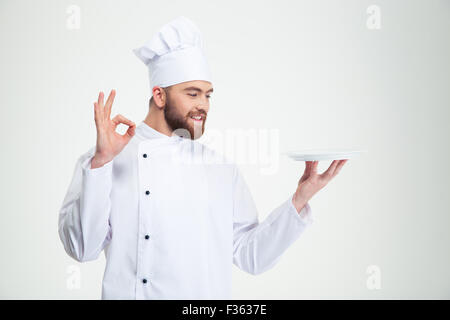 Porträt eines lächelnden Mann Chef zeigt ok Zeichen und leeren Teller isoliert auf weißem Hintergrund Stockfoto