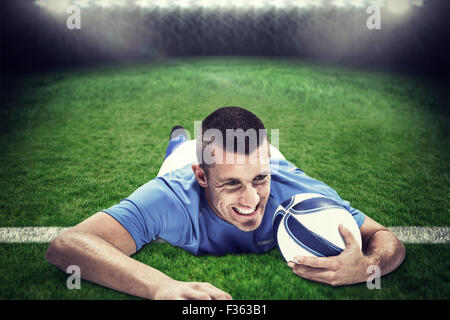 Zusammengesetztes Bild zuversichtlich Rugby-Spieler vorne liegend, mit ball Stockfoto