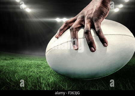 Zusammengesetztes Bild der freigestellten Bild des Sportlers mit Rugby-ball Stockfoto