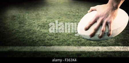 Zusammengesetztes Bild des Rugby-Spieler, die Füße auf den ball zu posieren Stockfoto