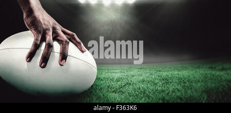 Zusammengesetztes Bild der freigestellten Bild des Sportlers mit Rugby-ball Stockfoto