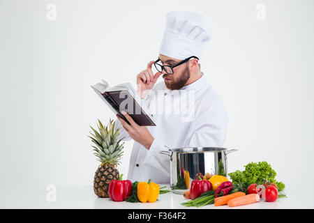 Porträt eines männlichen Chef-Kochs in Gläsern Rezept Buch isoliert auf weißem Hintergrund Stockfoto