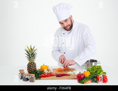 Porträt einer schönen männlichen Chef Koch Schneiden von Gemüse isoliert auf weißem Hintergrund Stockfoto