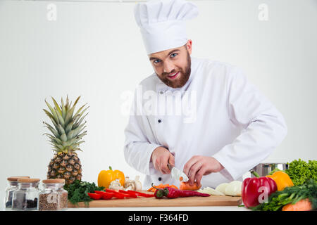Porträt von einem glücklichen männlichen Chef Koch Schneiden von Gemüse isoliert auf weißem Hintergrund Stockfoto