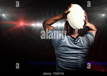 Zusammengesetztes Bild der Rückansicht der Sportler wirft Rugby-ball Stockfoto