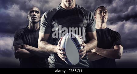Zusammengesetztes Bild des nachdenklichen Rugby-Spieler mit ball Stockfoto
