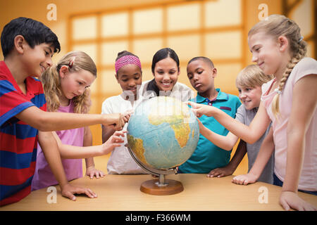 Zusammengesetztes Bild der niedlichen Schüler und Lehrer im Globe in Bibliothek suchen Stockfoto