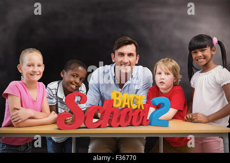 Zusammengesetztes Bild von Lehrer und Schüler lächelnd in die Kamera in Bibliothek Stockfoto