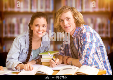 Zusammengesetztes Bild von College-Studenten, die Hausaufgaben in Bibliothek Stockfoto