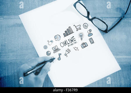 Zusammengesetztes Bild der linken Hand schreiben auf weißen Seite auf Arbeitstisch Stockfoto