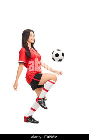Voller Länge Profil Schuss ein weibliche Fußball-Spieler jonglieren einen Ball auf dem Knie isoliert auf weißem Hintergrund Stockfoto