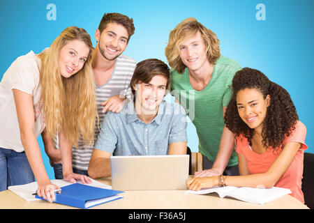 Zusammengesetztes Bild von College-Studenten mit Laptop in der Bibliothek Stockfoto