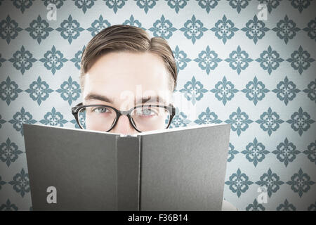 Zusammengesetztes Bild geeky Mannes Blick auf Buch Stockfoto
