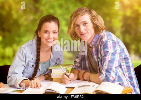 Zusammengesetztes Bild von College-Studenten, die Hausaufgaben in Bibliothek Stockfoto
