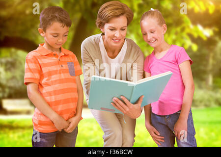 Zusammengesetztes Bild des Lehrers Buch mit Schülerinnen und Schülern in Bibliothek Stockfoto