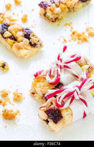 Müsli oder Müsli Bars mit Preiselbeeren auf weißem Hintergrund aus Holz. Stockfoto