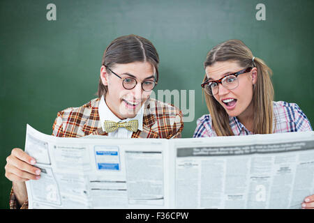 Zusammengesetztes Bild von geeky Hipster, die Zeitung zu lesen Stockfoto
