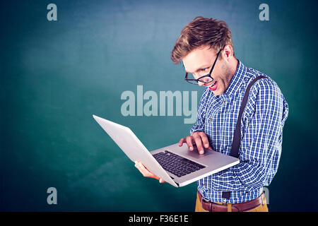 Zusammengesetztes Bild von geeky Geschäftsmann mit seinem laptop Stockfoto