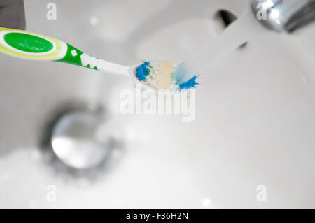 Zahnbürste unter fließendem Wasser aus einem Wasserhahn gespült Stockfoto