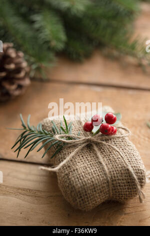 Natürliche Ferien verpackt Geschenk mit Beeren der Stechpalme Stockfoto