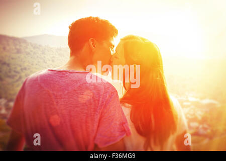 Jung, paar in der Sonne küssen Stockfoto