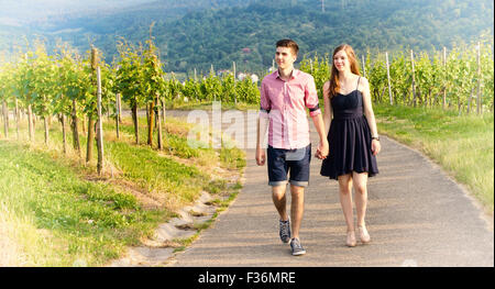 Junges Paar zu Fuß auf einem Weg in einem Weinberg Stockfoto