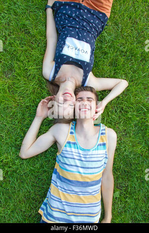 Glückliches, junges Paar im Grass liegen Stockfoto
