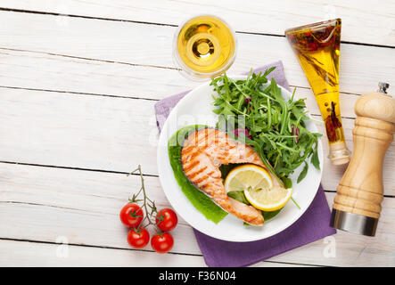 Gegrillter Lachs und Whtie Wein auf Holztisch. Draufsicht mit Textfreiraum Stockfoto