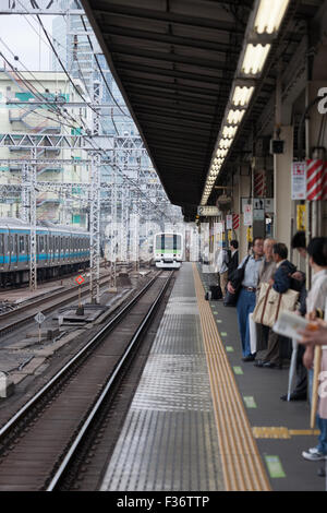 Plattform mit grünen weißen Zug in Ferne Tokio Japan Stockfoto