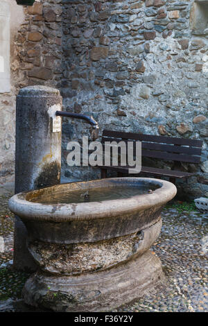 Die Alterung der Brunnen und die Mulde auf der Seite einer Straße im mittelalterlichen Dorf Yvoire, Frankreich Stockfoto