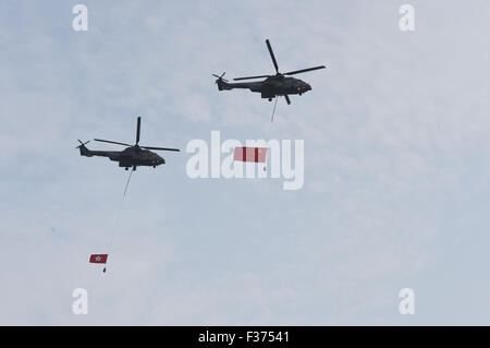 Hong Kong, China. 1. Oktober 2015. Zwei Hubschrauber hängen die chinesische Nationalflagge und die Flagge von Hong Kong Special Administrative Region fliegen vorbei, während eine nationale Flagge Anhebung Zeremonie Kennzeichnung, die der Gründung der Volksrepublik China Golden Bauhinia Square in Hong Kong Special Administrative Region, Süd-China, 1. Oktober 2015 stattfindet. Bildnachweis: Lui Siu Wai/Xinhua/Alamy Live-Nachrichten Stockfoto