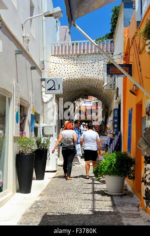 Touristen, die zu Fuß durch eine typische Straße in der Hauptstadt Fira Santorini Griechenland Stockfoto