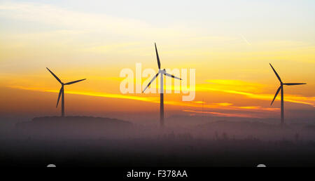 UK Dawn Wetter. Diesig, neblig, dunstiger Morgen bei Sonnenaufgang, über die drei 260 "hohe Turbinen, erneuerbare Energien Windpark auf dem Land vom Bauernhof Klippe, mawdesley Moss Windpark. Die umstrittenen Pläne diese drei privaten Rund- und kleinen Maßstab zu installieren, Windkraftanlagen in Chorley Dorf löste eine verärgerte Antwort von Bewohnern zitieren Umweltbelange Stockfoto