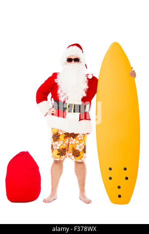 Glücklich Weihnachtsmann stehend mit Surfbrett Stockfoto