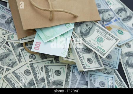 eine Menge Geld aus einer Papiertüte. Dollar und Euro Stockfoto