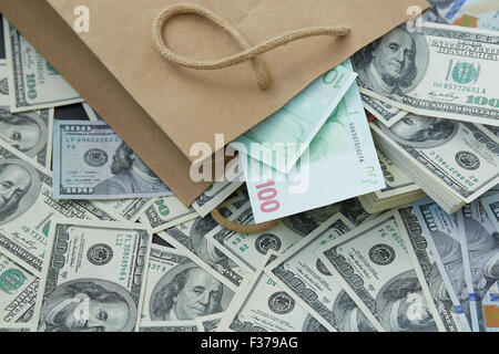 eine Menge Geld aus einer Papiertüte. Dollar und Euro Stockfoto