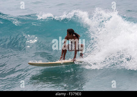 Junge Mann die Wellen surfen Surfer, Anse Patates, Indischer Ozean, La Digue Island, Seychellen Stockfoto