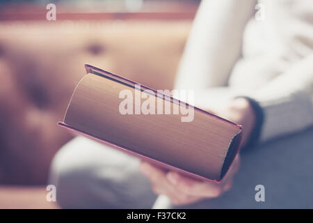 Ein großes Buch in der Hand eines Mannes hautnah Stockfoto