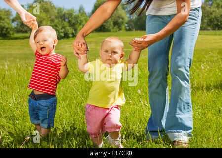 Babys lernen, wie man zu Fuß halten Mütter Hände Stockfoto