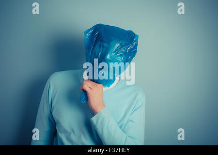 Ein Mann mit einer Plastiktüte über dem Kopf erstickt Stockfoto