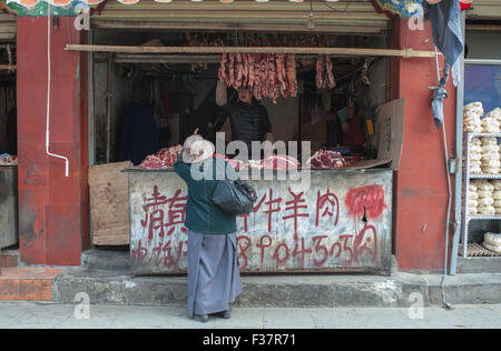 Metzger-Shop in Lhasa, Tibet. Eine Frau kauft Fleisch von einem Metzger in Tibet Stockfoto