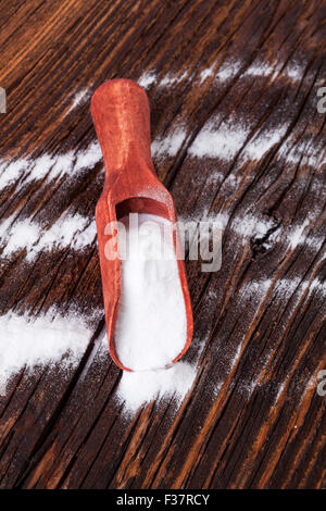 Backpulver auf Holzlöffel auf Holz braun strukturierten Hintergrund. Stockfoto