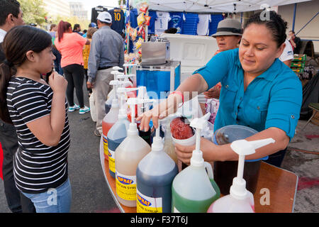 Hispanic Frau machen Schnee Kegel für Kunden - USA Stockfoto