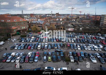 Hohen Blick auf Skyline von York (England, Vereinigtes Königreich) von Clifford es Tower. Passanten & Autos geparkt in einem geschäftigen, überfüllten Schloss Auto Park, Gebäude der Stadt über. Stockfoto