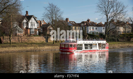 Top Deck Passagiere auf Vergnügen Bootsfahrt auf dem Fluss Ouse (York, England, UK) sind gegen die Kälte im Winter sonnig mit blauem Himmel gewickelt. Stockfoto