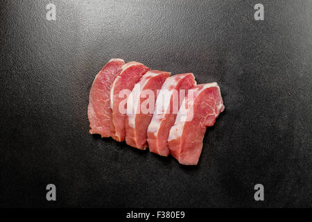 Rohes Fleisch Steaks auf schwarz strukturierten Hintergrund Stockfoto