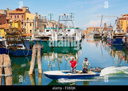 Kleines Fischerboot am Kanal mit Fischkuttern im Hintergrund Chioggia venezianischen Lagune Veneto Italien Europa Stockfoto
