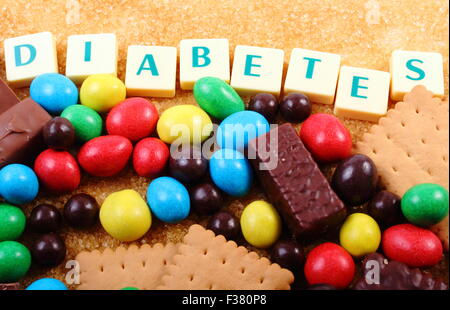 Haufen von süßen Bonbons und Kekse mit braunen Zuckerrohr Zucker und Wort Diabetes, ungesundes Essen, Konzept von diabetes Stockfoto