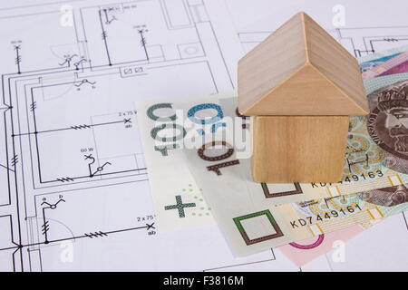 Haus-Form aus Holzklötzen und polnischen Währung Geld auf elektrische Konstruktionszeichnungen des Hauses, Stockfoto